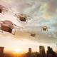 Five drones flying over a city skyline at sunset